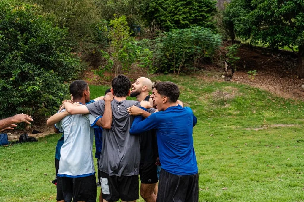 Grupo de homens em abraço, demonstrando união